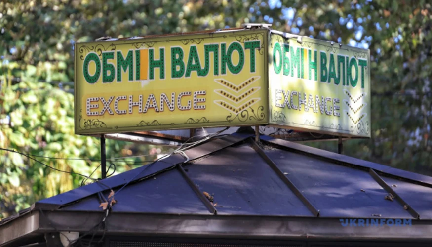 Банкноти долара та євро на тлі графіка котирувань на міжбанківському валютному ринку
